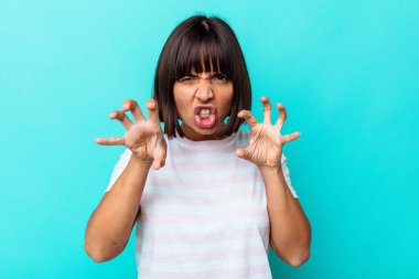 Mavi arka planda izole edilmiş genç melez kadın gergin ellerle çığlık atıyor..