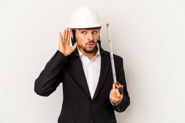 Miğfer takan ve taksimetre tutan genç bir mimar gri arka planda bir dedikoduyu dinlemeye çalışıyor..