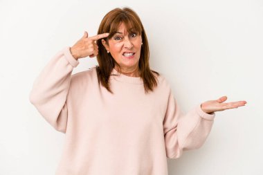 Beyaz arka planda izole edilmiş orta yaşlı beyaz kadın elinde bir ürün tutuyor ve.