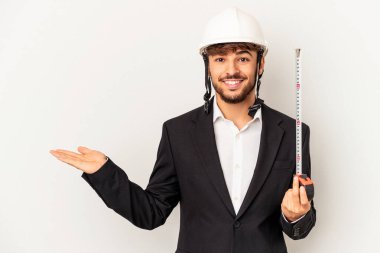 Miğfer takan ve taksimetre tutan genç bir mimar gri arka planda bir fotokopi alanı ve belinde bir el daha olduğunu gösteriyor..