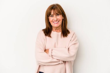 Beyaz arka planda kendini güvende hisseden, kararlılıkla kollarını kavuşturan orta yaşlı beyaz bir kadın..