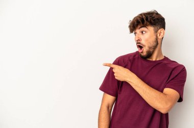 Genç melez adam arka plandaki gri noktalarda izole edilmiş başparmak uzakta, gülüyor ve kaygısız..