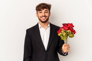 Genç melez adam elinde gül buketi tutuyor beyaz arka planda izole edilmiş mutlu, güler yüzlü ve neşeli.