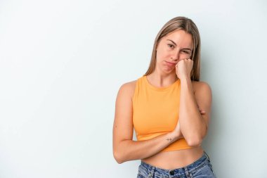 Mavi arka planda izole edilmiş, üzgün ve dalgın hisseden, kopyalama alanına bakan beyaz bir kadın..