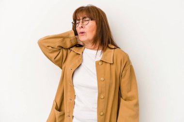 Orta yaşlı beyaz kadın beyaz arka planda izole edilmiş dirsek masajı yapıyor, kötü bir hareketin ardından acı çekiyor..