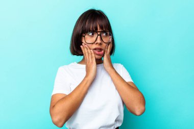 Mavi arka planda izole edilmiş genç bir ırk kadını. Güçlü bir diş ağrısı, azı dişi ağrısı var..