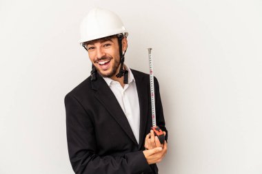 Miğfer takan ve taksimetre tutan genç mimar gri arka planda gülüp eğleniyor..