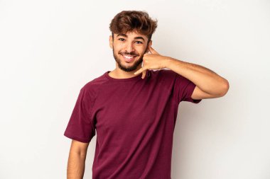 Genç melez adam gri arka planda izole edildi. Parmakları olan bir cep telefonu hareketi gösteriyor..