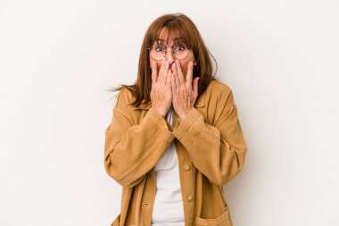 Beyaz arka planda izole edilmiş orta yaşlı beyaz kadın şok olmuş, ağzı ellerle kaplanmış, yeni bir şey keşfetmeye hevesli..