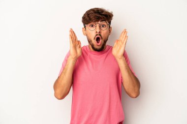 Genç melez adam gri arka planda izole edildi. Şaşırdı ve şok oldu..