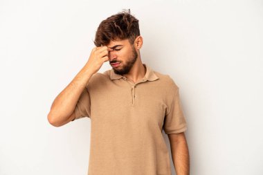 Genç melez adam gri arka planda izole edilmiş, başı ağrıyor, yüzüne dokunuyor..