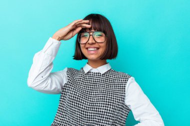 Mavi arka planda soyutlanmış genç melez bir kadın. Gülen, kaygısız, doğal duygular..