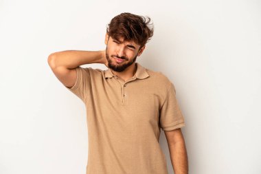 Genç melez adam gri arka planda izole edildi. Stres yüzünden boynu ağrıyor, masaj yapıyor ve elle dokunuyor..