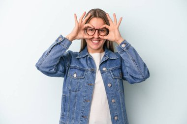 Kafkasyalı genç bir kadın mavi arka planda izole edilmiş. Heyecanlı..