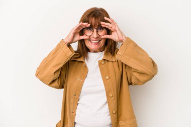 Beyaz arka planda izole edilmiş orta yaşlı beyaz bir kadın gözlerinde sorun olmadığını gösteriyor.