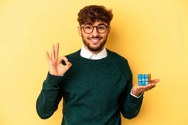 Mladý Smíšený Závod Muž Drží Rubiks Kostka Izolované Žlutém Pozadí — Stock fotografie