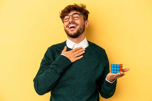 Mladý Smíšený Závod Muž Drží Rubiks Kostky Izolované Žlutém Pozadí — Stock fotografie