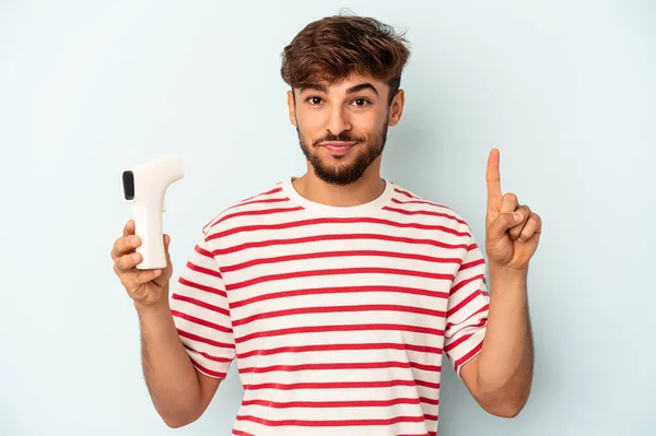 Joven Hombre Raza Mixta Sosteniendo Termómetro Aislado Sobre Fondo Azul — Foto de Stock