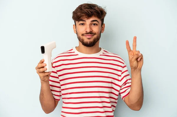 Young Mixed Race Man Holding Thermometer Isolated Blue Background Showing — 图库照片