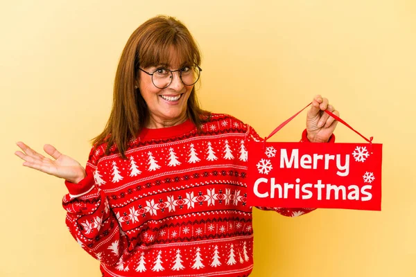 Middle Age Caucasian Woman Holding Merry Christmas Placard Isolated Yellow — Stock Photo, Image