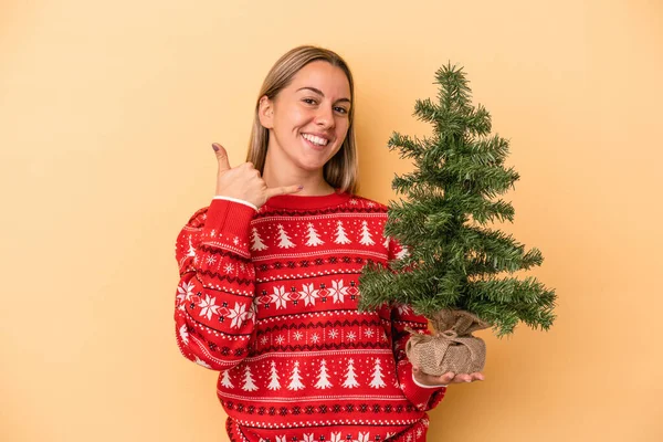 Jovem Caucasiana Segurando Uma Pequena Árvore Natal Isolada Fundo Amarelo — Fotografia de Stock
