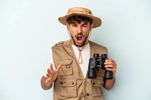 Young Mixed Race Man Holding Binoculars Isolated Blue Background Screaming — 图库照片