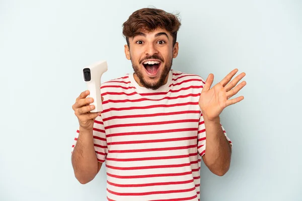 Young Mixed Race Man Holding Thermometer Isolated Blue Background Receiving — Stockfoto