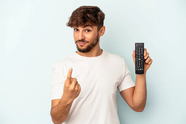 Jovem Mestiço Segurando Controlador Isolado Fundo Azul Apontando Com Dedo — Fotografia de Stock