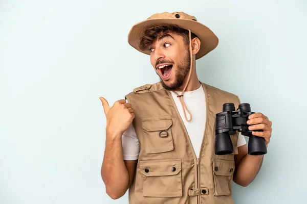 Jovem Mestiço Segurando Binóculos Isolados Pontos Fundo Azuis Com Dedo — Fotografia de Stock