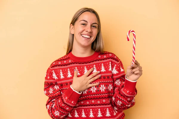 Sarı Arka Planda Izole Edilmiş Bir Noel Sopası Tutan Genç — Stok fotoğraf