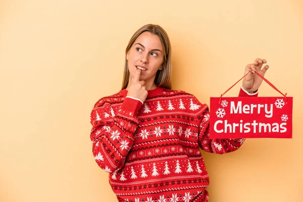 Mladá Běloška Drží Veselý Vánoční Plakát Izolovaný Žlutém Pozadí Uvolněně — Stock fotografie
