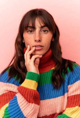 Arjantinli genç bir kadın pembe arka planda izole edilmiş.