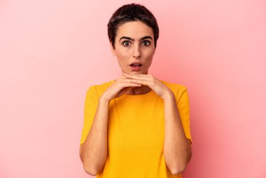 Kafkasyalı genç bir kadın mavi arka planda izole edilmiş şans için dua ediyor, şaşırmış ve ağzını açıp önüne bakıyor..