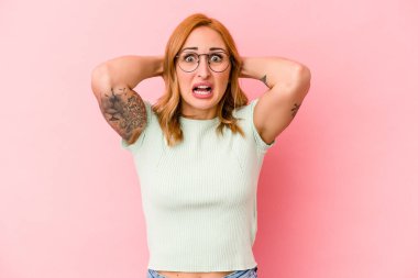 Pembe arka planda izole edilmiş beyaz bir kadın öfkeyle bağırıyor..