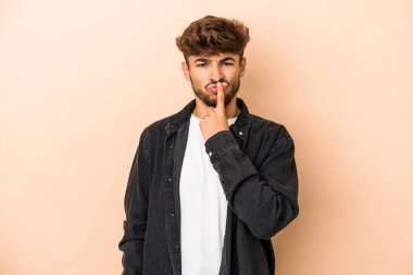 Young arab man isolated on beige background thinking and looking up, being reflective, contemplating, having a fantasy.