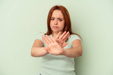 Yeşil arka planda izole edilmiş genç beyaz kadın elini uzatmış, dur işareti göstererek seni engelliyor..