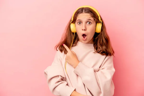 Pequeña Chica Caucásica Escuchando Música Aislada Sobre Fondo Rosa Apuntando — Foto de Stock