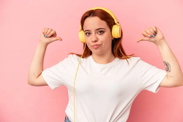 Young Caucasian Woman Listening Music Isolated Pink Background Feels Proud — Stock Photo, Image