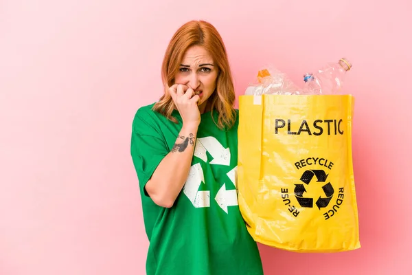 Young Caucasian Woman Recycled Plastic Isolated Pink Background Biting Fingernails — Foto Stock