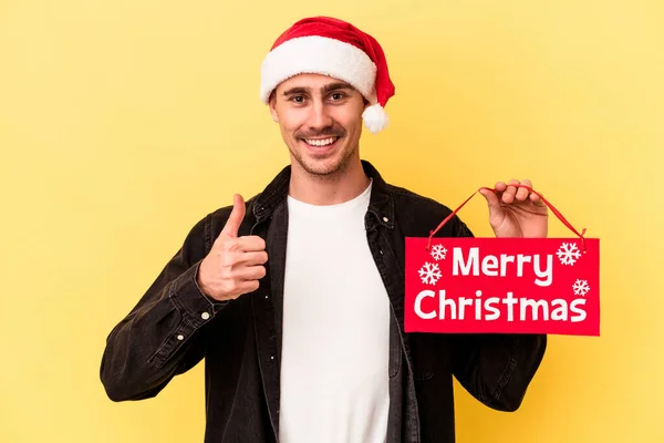 Jonge Blanke Man Met Een Vrolijk Kerstbordje Geïsoleerd Gele Achtergrond — Stockfoto