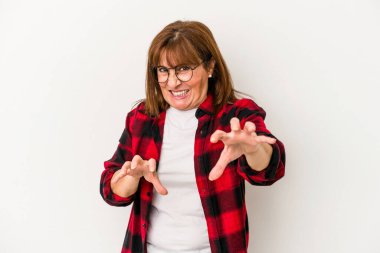 Beyaz arka planda izole edilmiş orta yaşlı beyaz kadın pençelerini kedi taklidi yaparken gösteriyor, agresif bir hareket..