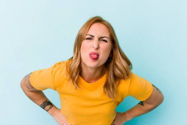 Mavi arka planda izole edilmiş beyaz bir kadın. Komik ve dost canlısı bir dil uzatıyor..