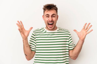 Beyaz arka planda izole edilmiş genç beyaz adam gökyüzüne haykırıyor, yukarı bakıyor, hayal kırıklığına uğramış..