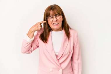 Beyaz arka planda izole edilmiş orta yaşlı beyaz kadın kulaklarını elleriyle kapatıyor..