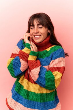 Arjantinli genç bir kadın pembe arka planda izole edilmiş.