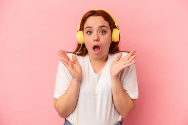 Pembe arka planda müzik dinleyen beyaz bir kadın şaşırmış ve şok olmuştu..