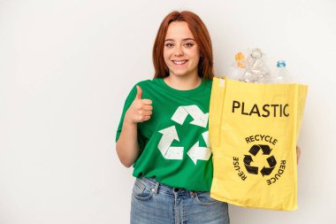 Young caucasian woman recycled plastic isolated on white background smiling and raising thumb up