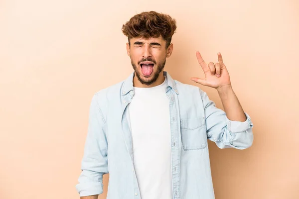 Young Arab Man Isolated Beige Background Showing Rock Gesture Fingers — Fotografia de Stock