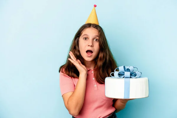 小さいですCaucasian女の子祝います彼女の誕生日保持Aケーキ絶縁上の青背景驚きとショック — ストック写真