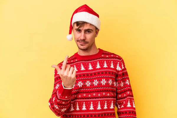 Mladý Kavkazský Muž Slaví Vánoce Izolované Žlutém Pozadí Ukazuje Prstem — Stock fotografie